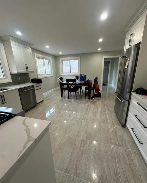 Open-plan kitchen and dining area with soft sage walls and white trim