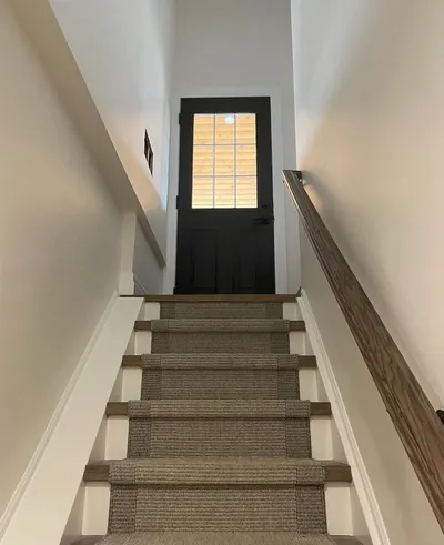 White stairwell with a black door at the top